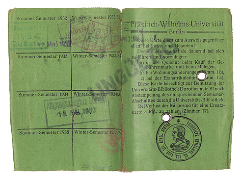 Green identification card filled out by hand with a passport photo and stamps from the university office.