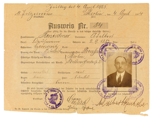 Identity card form in Gothic type, filled in by hand. A passport photograph is glued to the specified field and stamped on each corner by Police Precinct 14.