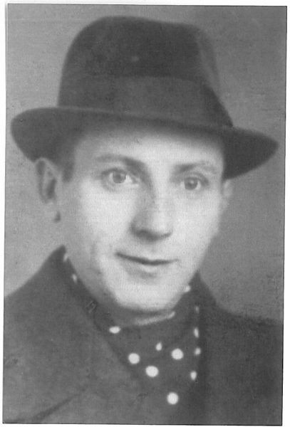 Black-and-white portrait of a man with a hat and a polka dot cravat