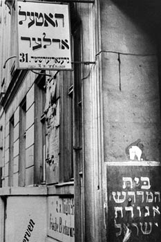 Entrance of the building at no. 31 with a view of the facade and Hebrew signs (partial view)