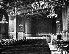 Historical view of the interior showing the stage with seats and chandeliers