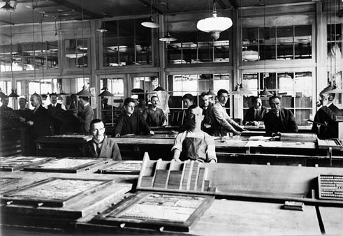 Men in front of tables with typecases