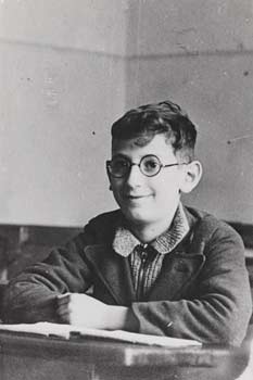 Boy with glasses sitting at a desk in school