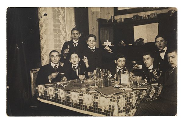 A group of friends in suits, drinking wine.