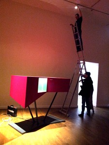 A showcase in magenta and people on a ladder