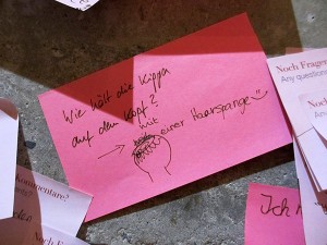 Post-it note in pink: "Wie hält die Kippa auf dem Kopf? - mit einer Haarspange" (How does a kippah stay on? - with a hair clip))