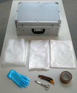 A case, bubble wrap, thick plastic wrap, tissue paper, gloves, scissors and cutter, tape