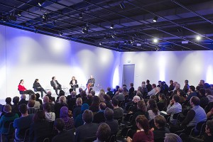 Five panelists on the stage in front of a big audience