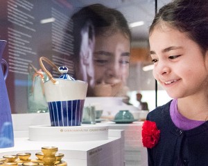 A girl looking at a showcase with ceramic objects