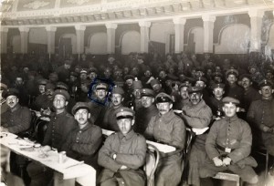 Men in uniform occupy seats in a theater auditorium. 