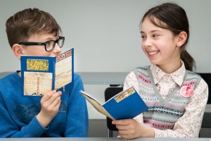 A boy and a girl showing their hand-made booklets