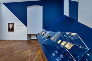 Interior view of the special exhibition. A few book on blue painted slope wall 