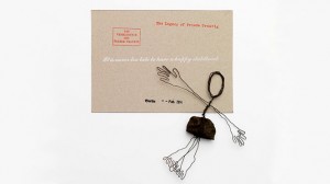A figurine made of wire and gravel stone lies on a postcard