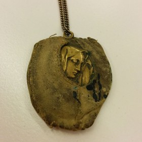 Golden pendant with the depiction of a women’s head