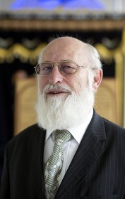 Elderly man in a suit with glasses and full beard