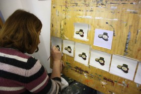 A woman is painting coins