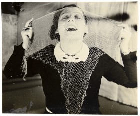 Portrait of a laughing woman with a transparent scarf in front of her face