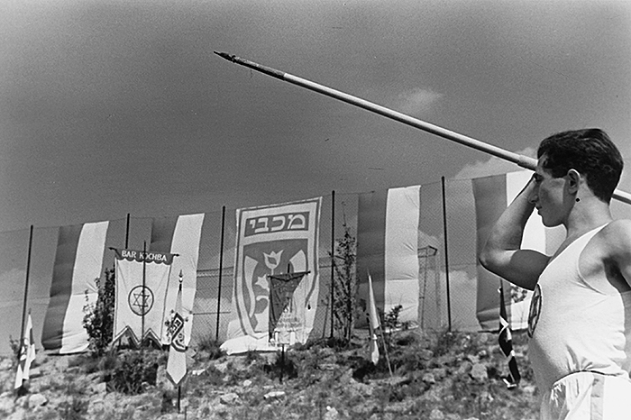 Black and white photo: javelin thrower at athletic grounds