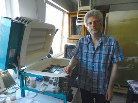 A man stands next to an electric kiln