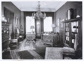 Black and white photography of a study, decorated with antiques and paintings