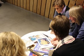 Four women sitting at a table with books