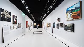 A white room with black ceiling and pictures on the walls