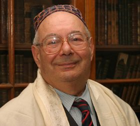 Portrait of an elderly man with glasses, kippah and tallit. 
