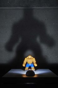 Action figure with huge shadow behind it on the wall