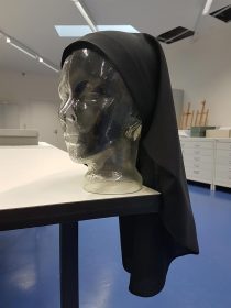 Transparent bust wearing a black veil.