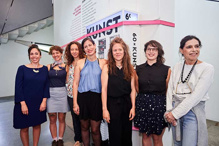Seven women in front of the art vending machine