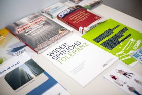 Various brochures lie on a table, with titles such as "Where does hatred of Jews come from?"