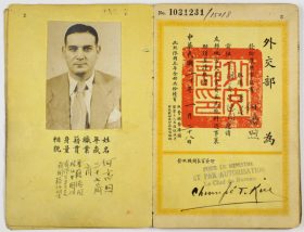 Yellow pages of a passport with Chinese letters, opened on the page with the photograph and a red stamp