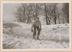 In the black-and-white photo, Walter is skiing up a small slope.