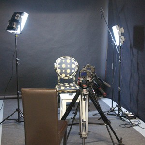 Der leere Stuhl bei den Dreharbeiten zwischen zwei Scheinwerfern und hinter einer Kamera