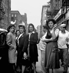 Schwarz-Weiß-Foto, auf dem mehrere Frauen auf einer Straße stehen und den Betrachter ansehen