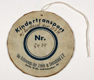 rundes Schild mit der Aufschrift »Kindertransport«, in der Mitte eine Nummer