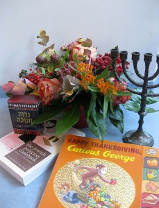Eine Menora, ein Blumenstrauß und das Buch »Curious George«