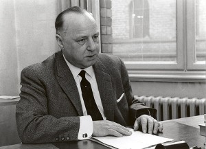 Ein Mann in Anzug und Krawatte an einem Schreibtisch