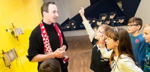 Ein Museumsführer mit einer Gruppe Kinder in der Ausstellung »Die Erschaffung der Welt«, ein kleiner Junge meldet sich