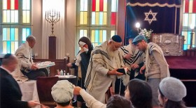 Farbfotografie einer Beschneidungsfeier in der Synagoge mit mehreren Personen