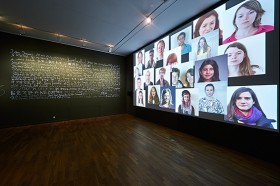 Ausstellungsraum mit Kalligrafie und Multiscreen-Installation