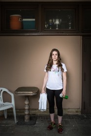 Junge Frau in Sportkleidung mit Handtuch und Trinkflasche