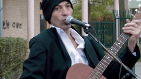 Portrait eines Mannes mit Gitarre am Mikrofon