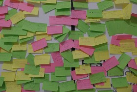 Wand mit lauter bunten Post-its, auf denen Schrift in verschiedenen Sprachen und gezeichnetete Davidsterne zu erkennen sind