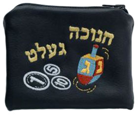 Ein schwarzer Geldbeutel, auf den ein Dreidel, Münzen und in hebräischen Buchstaben das jiddische Wort »Chanukka-Gelt« gestickt ist.