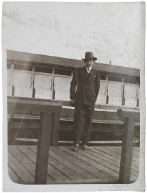 Schwarz-weiß Fotografie eines jungen Mannes, der vor einer Reihe Umkleiden steht