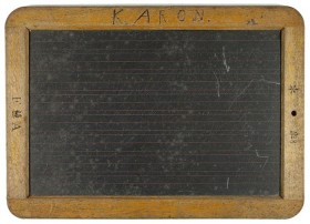 Eine schwarze Tafel mit Holzrahmen, auf dem K. ARON steht.