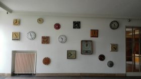 Eingangsbereich mit einer Wand voller Uhren.