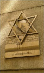 Davidstern, der ein zerbrochenes Synagogenrelief enthält, darunter die Aufschrift »Zur mahnenden Erinnerung«