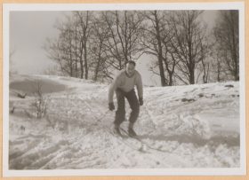 Auf dem schwarz-weiß Foto fährt Walter auf Skiern stehend einen kleinen Abhang hinab.